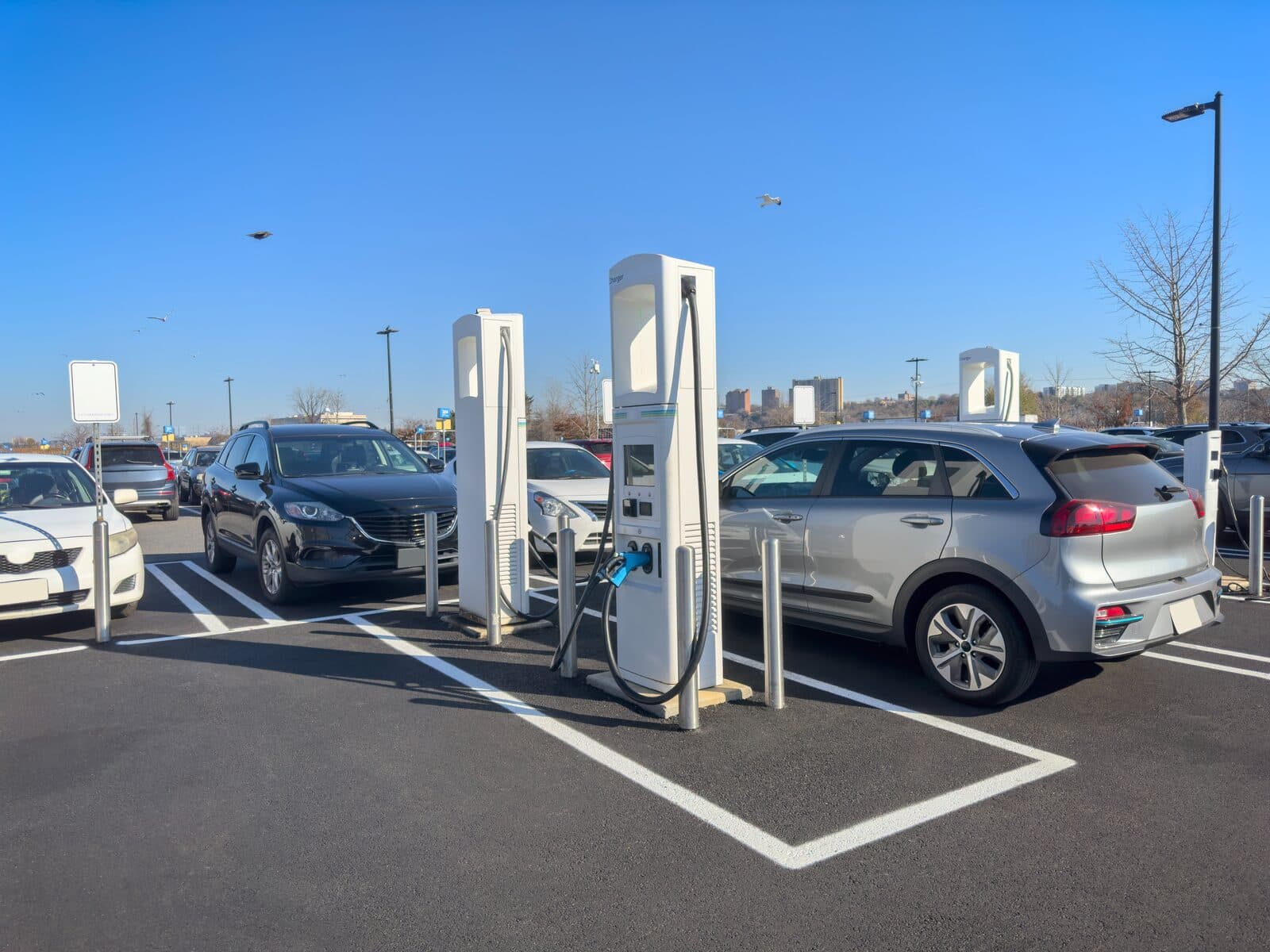 Electric vehicles charging at fast charging stations in a commercial parking lot