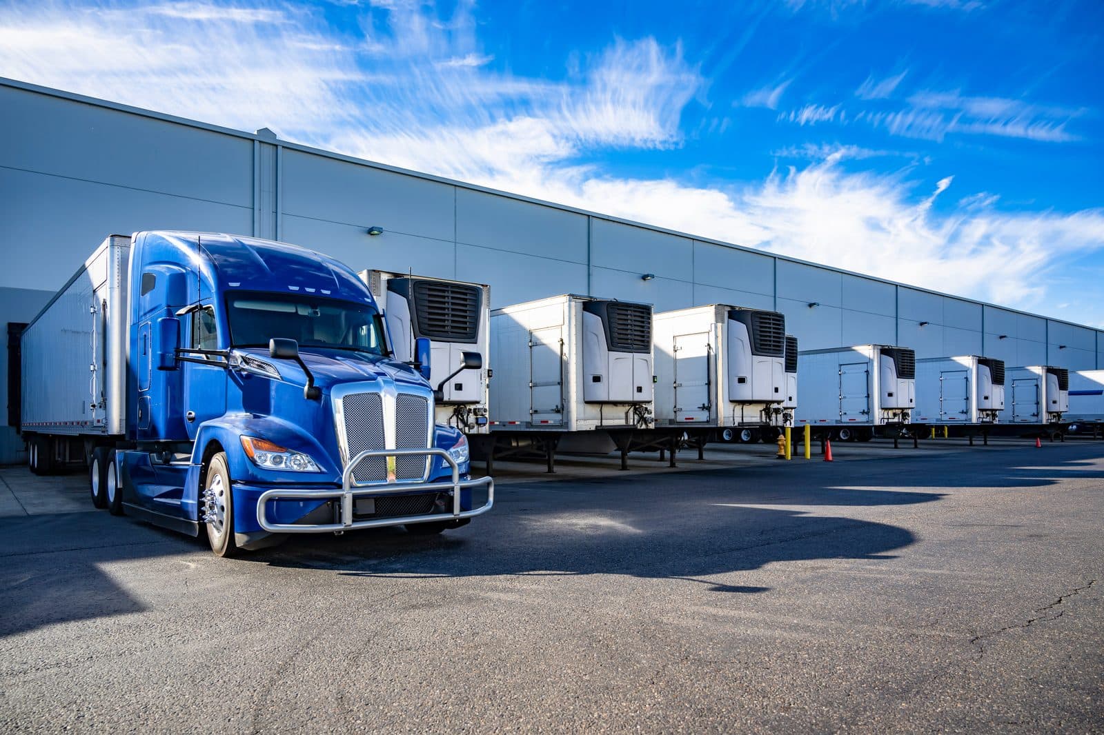 Freight trailers staged at dock doors loading material for direct delivery